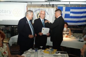 Ο βΔ Ανδρέας παραδίδει το σήμα της διάκρισης Paul Harris Fellow στον απερχόμενο Πρόεδρο Κώστα, υπό το άγρυπνο βλέμμα του Χρήστου Καφέζα